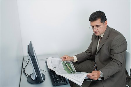 simsearch:632-07674665,k - Businessman reading newspaper in office Stock Photo - Premium Royalty-Free, Code: 632-06354064