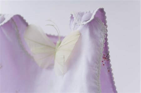 fake butterflies - Faux papillon au repos sur les vêtements pour bébés Photographie de stock - Premium Libres de Droits, Code: 632-06354112