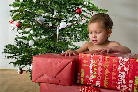 Baby girl touching stacked Christmas presents Stock Photo - Premium Royalty-Free, Code: 632-06354178