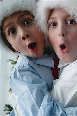 simsearch:632-06118319,k - Boys wearing Santa hats, hugging and making surprised faces Stock Photo - Premium Royalty-Free, Code: 632-06354170