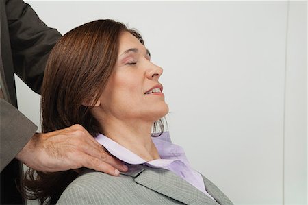 Mature businesswoman having her shoulders massaged Stock Photo - Premium Royalty-Free, Code: 632-06354181