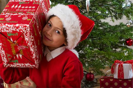 simsearch:632-06354083,k - Boy holding Christmas present on his shoulder, portrait Fotografie stock - Premium Royalty-Free, Codice: 632-06354225