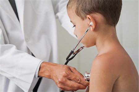 examen de pecho - Doctor letting boy listen to own chest with stethoscope Foto de stock - Sin royalties Premium, Código: 632-06354320