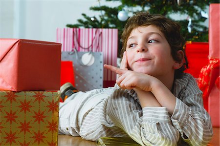 simsearch:632-06354055,k - Boy lying on floor pointing at Christmas presents Stock Photo - Premium Royalty-Free, Code: 632-06354351