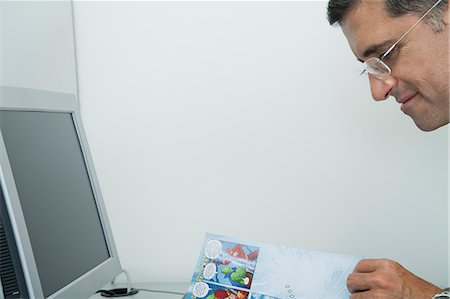 simsearch:632-07674665,k - Mature man reading comic book in office Stock Photo - Premium Royalty-Free, Code: 632-06354377