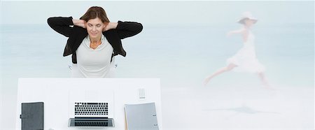 escape - Mature businesswoman sitting at desk, imagining herself at the beach Stock Photo - Premium Royalty-Free, Code: 632-06354448