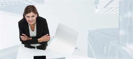 studio portrait above woman - Mature businesswoman smiling confidently with skyscrapers superimposed on background Stock Photo - Premium Royalty-Free, Code: 632-06354449