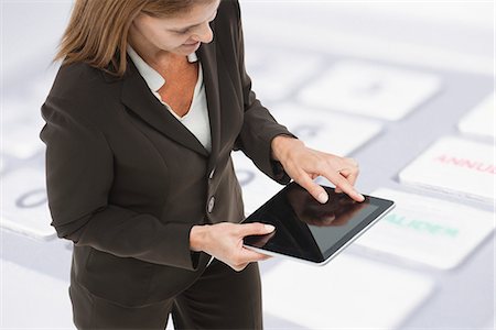 Businesswoman using digital tablet, close-up image of keyboard superimposed on background Stock Photo - Premium Royalty-Free, Code: 632-06354464