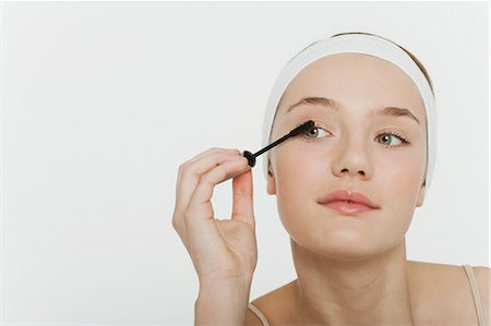 Preteen girl putting on mascara Stock Photo - Premium Royalty-Free, Code: 632-06353935