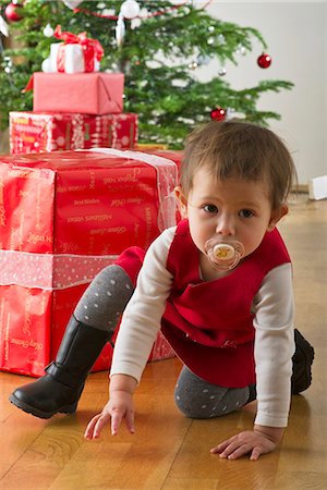 simsearch:632-06354083,k - Baby girl crouching in front of Christmas presents Fotografie stock - Premium Royalty-Free, Codice: 632-06353945