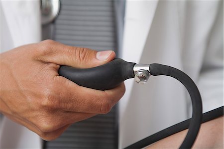Doctor squeezing bulb on blood pressure gauge, cropped Foto de stock - Sin royalties Premium, Código: 632-06353947