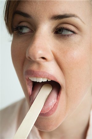 Jeune femme jouissant de la bouche a examiné avec abaisse-langue Photographie de stock - Premium Libres de Droits, Code: 632-06353948