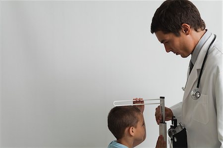 Doctor measuring little boy during check-up Stock Photo - Premium Royalty-Free, Code: 632-06353959