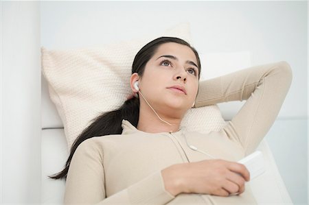 simsearch:640-08089386,k - Young woman lying on sofa, listening to MP3 player Stock Photo - Premium Royalty-Free, Code: 632-06404263