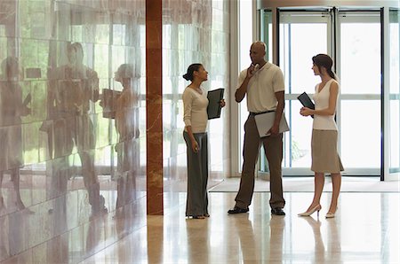 female office workers talking in the hallway - Colleagues talking in lobby, backlit Stock Photo - Premium Royalty-Free, Code: 632-06404449