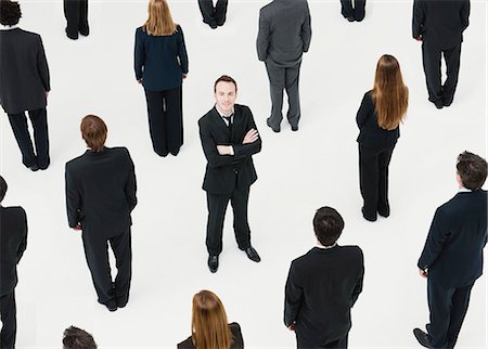 Businessman with arms crossed standing in midst of anonymously dressed business professionals Stock Photo - Premium Royalty-Free, Code: 632-06404602