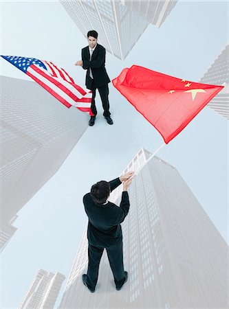 simsearch:632-06404590,k - Homme debout face à face, agitant des drapeaux chinois et américains Photographie de stock - Premium Libres de Droits, Code: 632-06404684