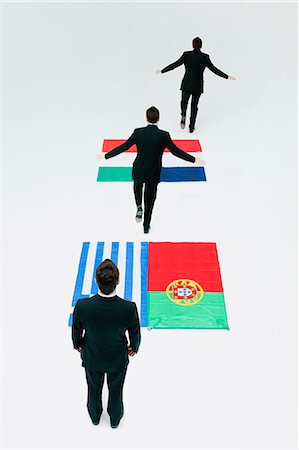 simsearch:632-06404623,k - Businessman running across Greek, Portuguese, Italian and French flags Stock Photo - Premium Royalty-Free, Code: 632-06404690