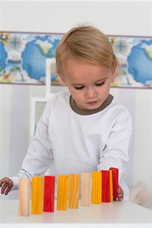 simsearch:632-06354108,k - Baby boy carefully lining up blocks Foto de stock - Royalty Free Premium, Número: 632-06779120