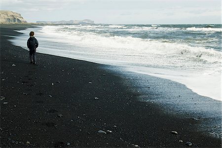 Boy walking on the beach watching the horizon, iceland Stock Photo - Premium Royalty-Free, Code: 632-06779136