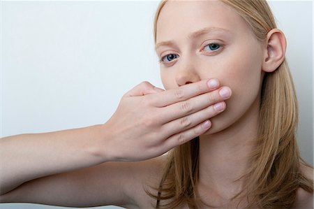 simsearch:632-06317597,k - Young woman covering mouth with hand Fotografie stock - Premium Royalty-Free, Codice: 632-06779140