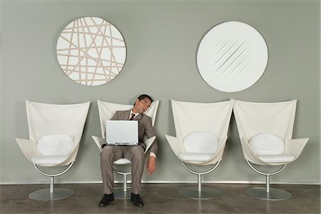Young businessman fell asleep in chair with laptop computer on lap Stock Photo - Premium Royalty-Free, Code: 632-06779199