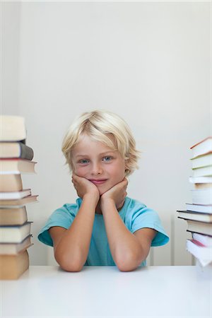 simsearch:632-05816453,k - Boy sitting between tall stacks of books, portrait Photographie de stock - Premium Libres de Droits, Code: 632-06779241