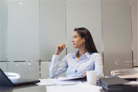 Businesswoman sitting at desk, looking away in thought Stock Photo - Premium Royalty-Free, Code: 632-06779281