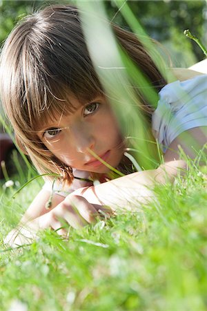 shy children - Girl lying in grass, portrait Stock Photo - Premium Royalty-Free, Code: 632-06779371