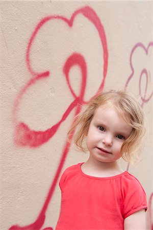 Little girl by wall with flower graffiti, portrait Foto de stock - Sin royalties Premium, Código: 632-06967595