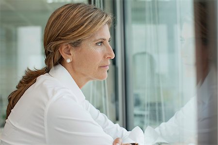 regarder par la fenêtre - Mature woman looking out window, portrait Photographie de stock - Premium Libres de Droits, Code: 632-06967703