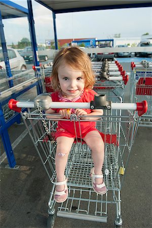 riding a shopping cart - Little girl sitting in shopping cart Stock Photo - Premium Royalty-Free, Code: 632-06967714