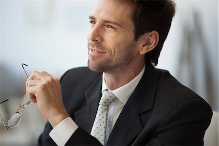 smile executives pictures - Businessman looking away in thought, glasses in hand Photographie de stock - Premium Libres de Droits, Code: 632-06967710