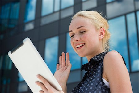 Young woman waving at digital tablet Stock Photo - Premium Royalty-Free, Code: 632-07161251