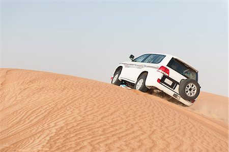 Sports utility vehicle driving up desert sand dune Photographie de stock - Premium Libres de Droits, Code: 632-07161273