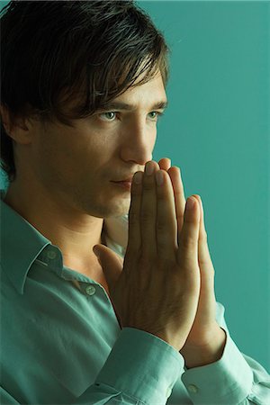 Man with hands clasped in prayer, close-up Foto de stock - Royalty Free Premium, Número: 632-07161335