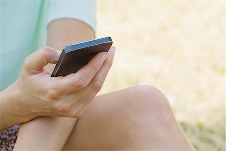 simsearch:6108-07969521,k - Woman using smartphone outdoors, cropped Stock Photo - Premium Royalty-Free, Code: 632-07161359