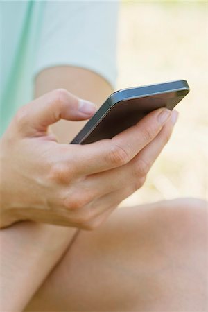 dial - Woman using smartphone outdoors, cropped Stock Photo - Premium Royalty-Free, Code: 632-07161360
