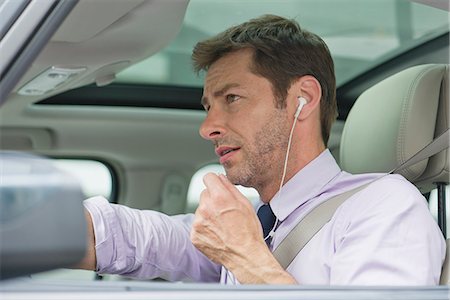 simsearch:632-08227418,k - Man using earphone headset while driving Foto de stock - Sin royalties Premium, Código: 632-07161439