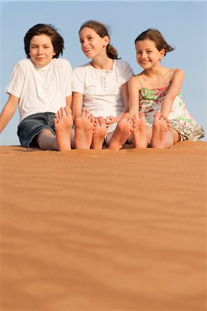 simsearch:633-08726392,k - Children sitting on sand dune Photographie de stock - Premium Libres de Droits, Code: 632-07161476