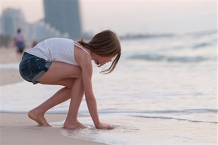 se pencher - Girl playing with water on beach Photographie de stock - Premium Libres de Droits, Code: 632-07161470