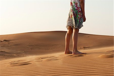 simsearch:632-03652319,k - Girl standing barefoot in desert, cropped Fotografie stock - Premium Royalty-Free, Codice: 632-07161473