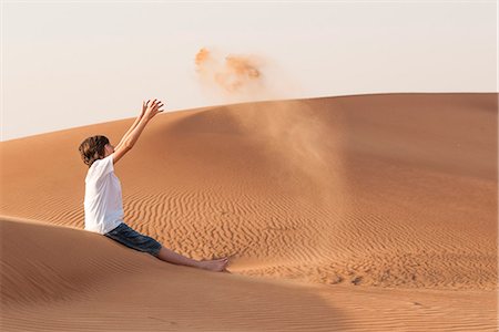 dunes family - Teenage boy playfully tossing sand into air Stock Photo - Premium Royalty-Free, Code: 632-07161485