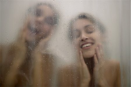 simsearch:632-07161489,k - Two women behind shower door, wiping faces Photographie de stock - Premium Libres de Droits, Code: 632-07161495