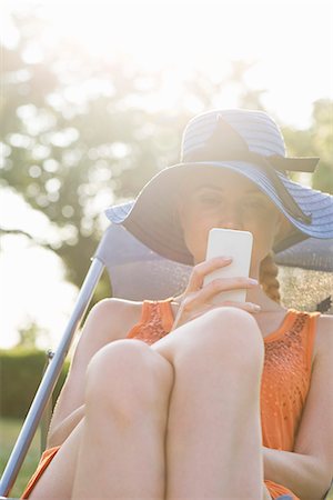 da solo - Young woman relaxing outdoors with smartphone Fotografie stock - Premium Royalty-Free, Codice: 632-07161516