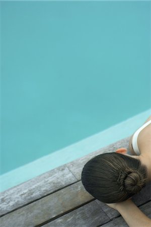 simsearch:695-05763702,k - Woman lying on deck next to pool Photographie de stock - Premium Libres de Droits, Code: 632-07161518