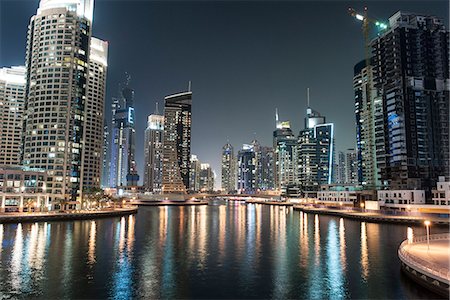 simsearch:649-07905096,k - Skyscrapers illuminating marina by night Photographie de stock - Premium Libres de Droits, Code: 632-07161554