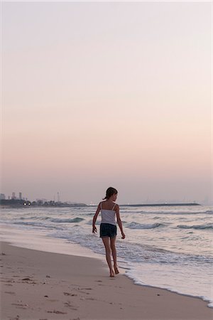 simsearch:632-03652319,k - Girl walking on beach, looking at sea Fotografie stock - Premium Royalty-Free, Codice: 632-07161582