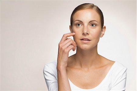 Young woman daydreaming, touching cheek, portrait Photographie de stock - Premium Libres de Droits, Code: 632-07161638