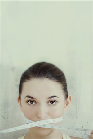 Woman with measuring tape wrapped across mouth Photographie de stock - Premium Libres de Droits, Code: 632-07161693